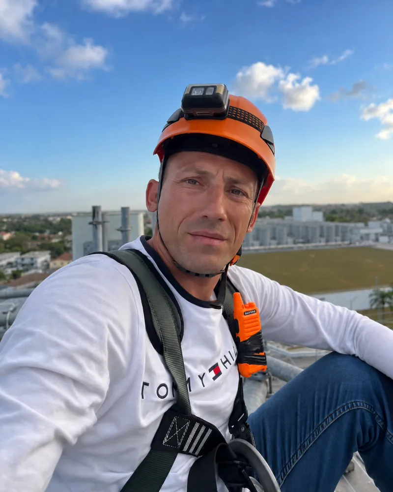 Dominika Tsybina's dad in safety gear on a rooftop work site