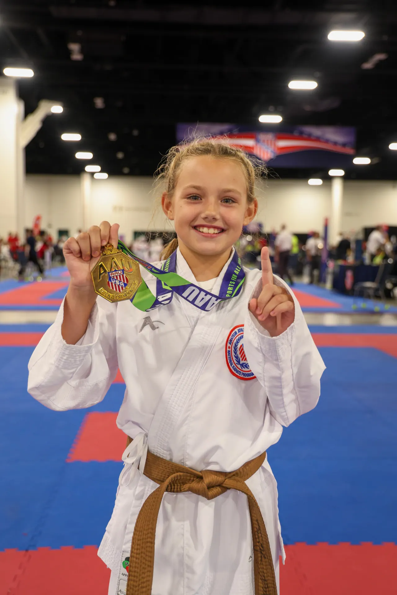 Karate athlete Dominika Tsybina in her karate gi holding a gold medal