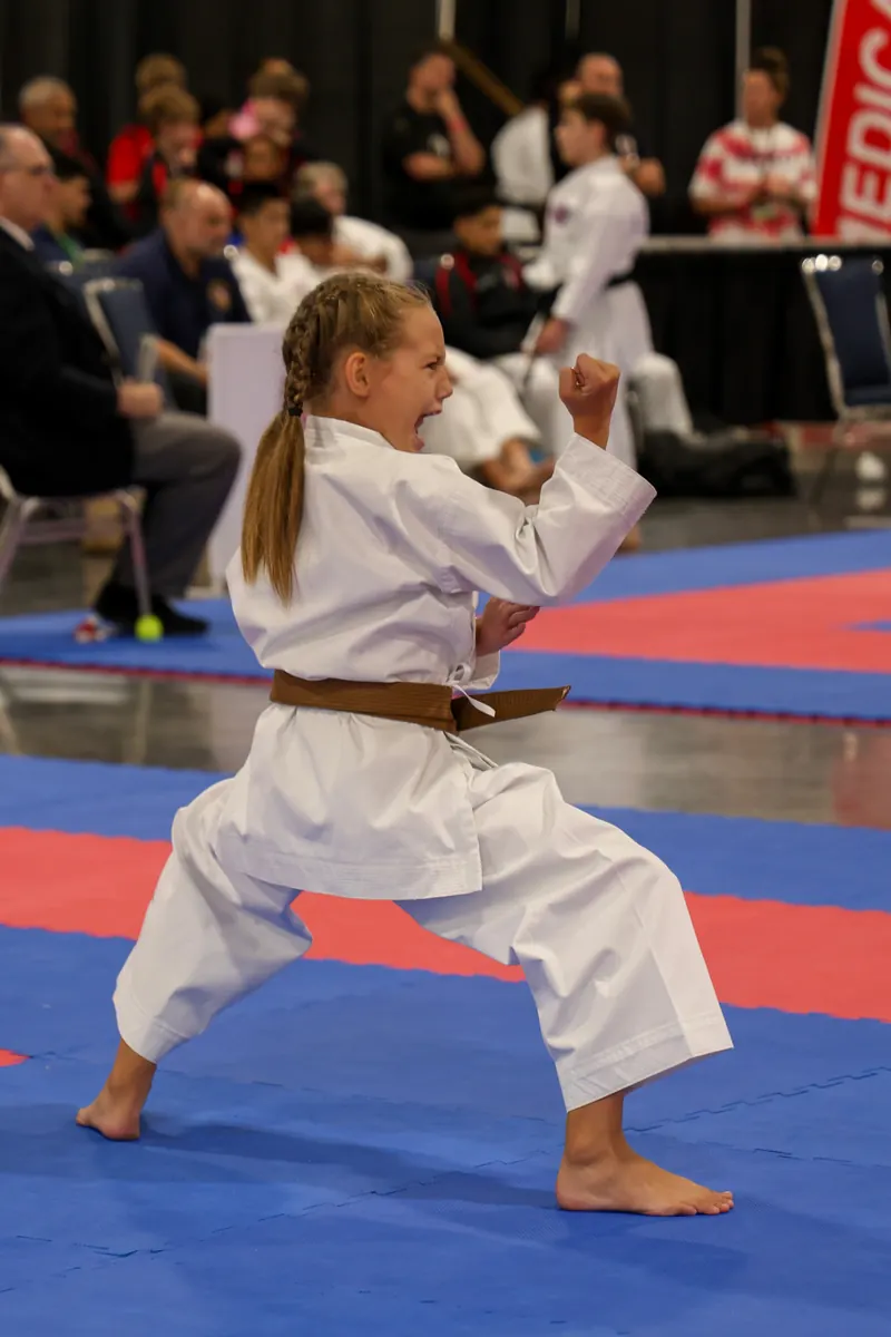 Dominika Tsybina delivering a kiai during a karate kata performance at a tournament
