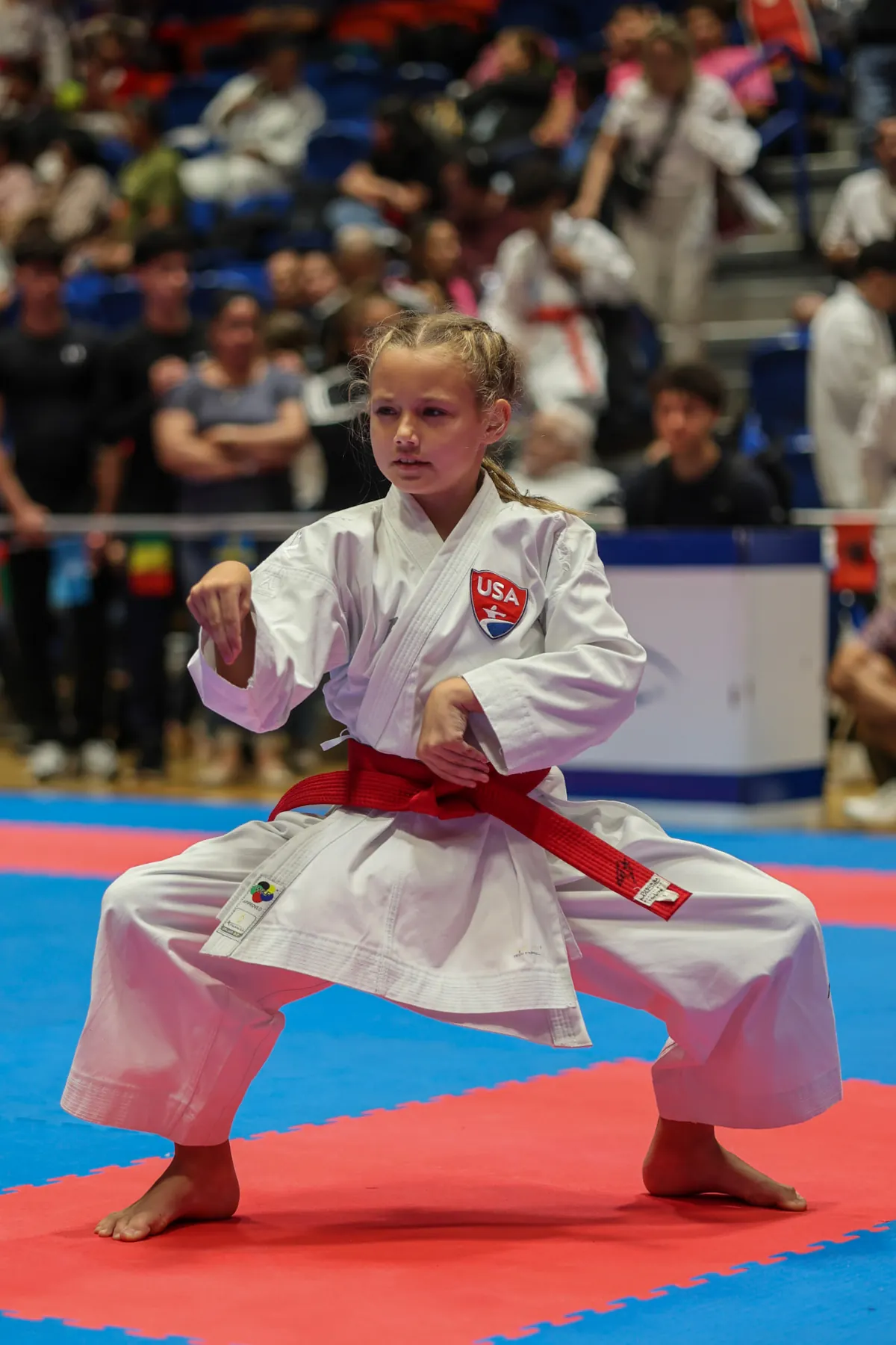 Dominika Tsybina performing a low karate kata stance on the competition tatami